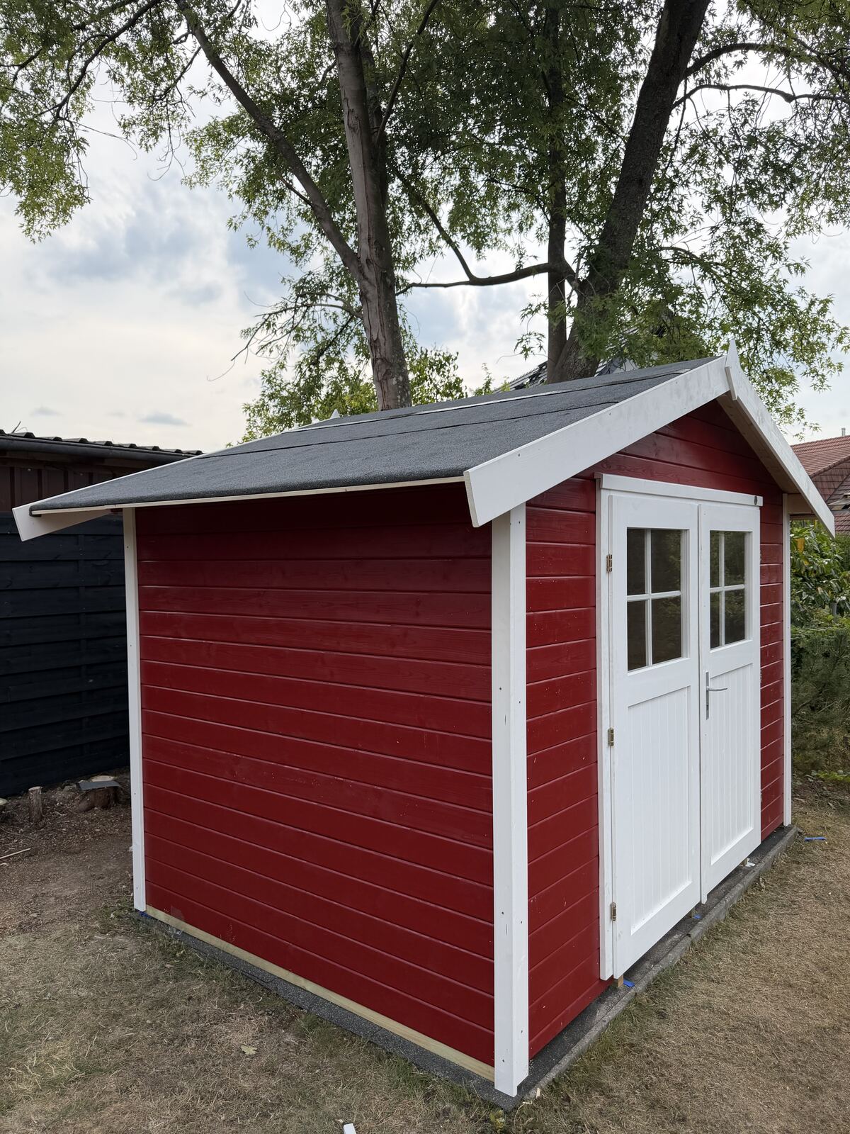 Fertig gebautes rotes Gartenhaus
