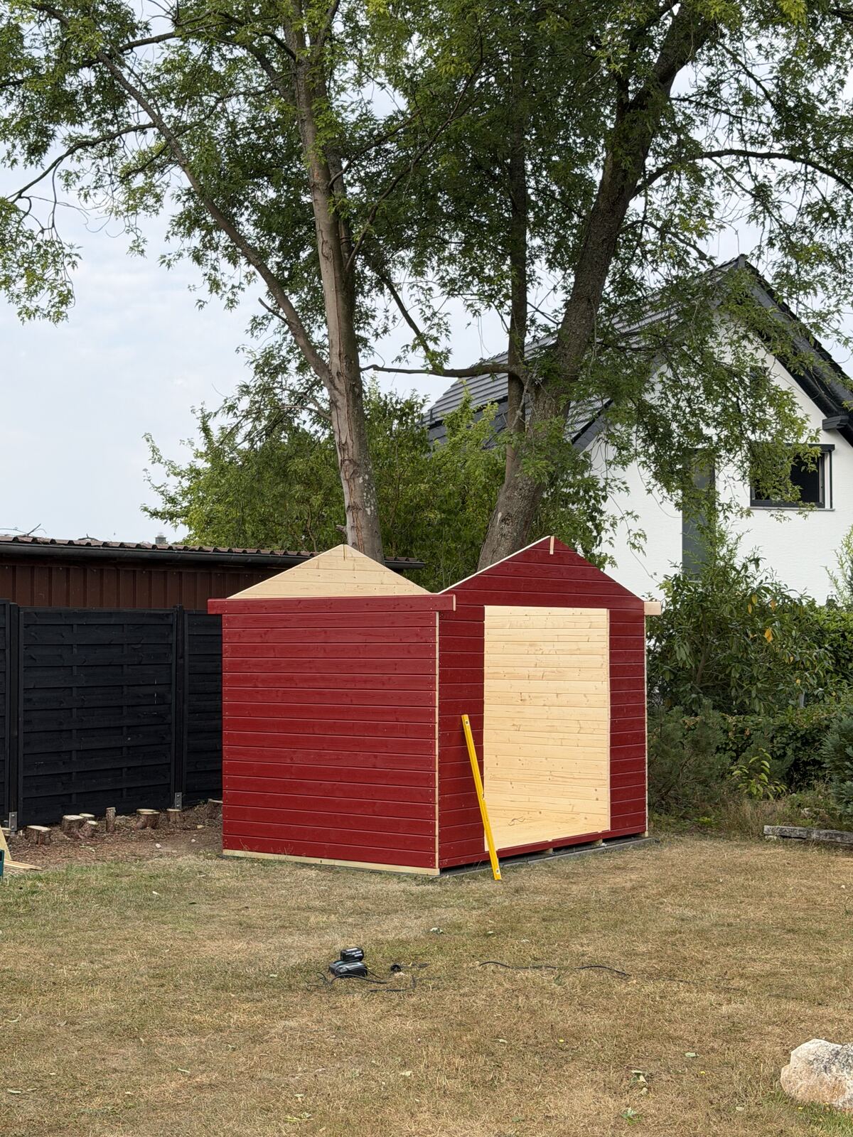 Gartenhaus im Rohbau mit roter Holzverkleidung